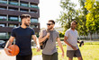 © Syda Productions - sport, leisure games and male friendship concept - group of men or friends going to play basketball outdoors