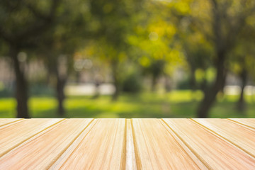 Wall Mural - Empty yellow wooden table with blurred city park on background. concept party, products, autumn background