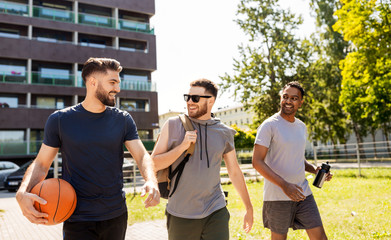 sport, leisure games and male friendship concept - group of men or friends going to play basketball 