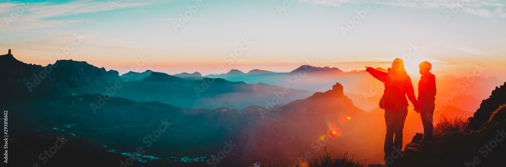 mother and son travel in mountains at sunset, panorama - obrazy, fototapety, plakaty 