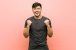© Asier - Young hispanic casual man cheering carefree and excited. Victory concept.