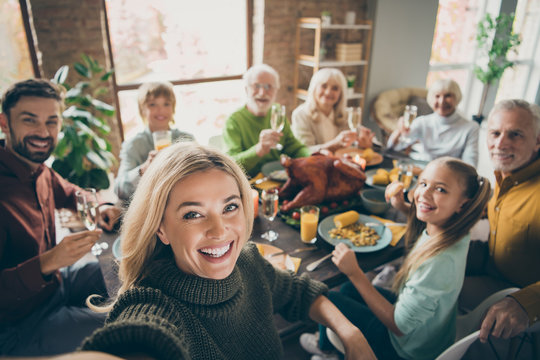 photo of big family sit feast dishes table around roasted turkey multi-generation relatives making g