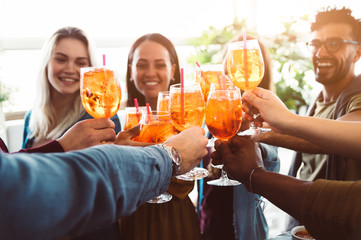 Group of happy friends drinking and toasting friends at a bar restaurant