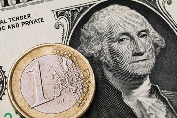 1 euro coin on the background of 1 dollar bill, close-up