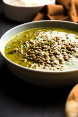 Wall Mural - Black Masoor Dal fry or Dhaba Style Sabut Red Lentil dhal tadka in green curry, served in a bowl. selective focus