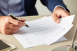 © 365mm/Stocksy - Manager in suit reading paper document
