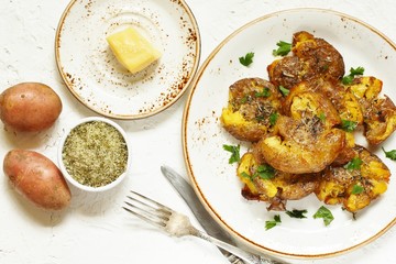 Sticker - crushed potatoes. smashed potatoes. recipes for Australian cuisine. the potatoes are boiled in a shell, broken and baked in an oven with spices. top view