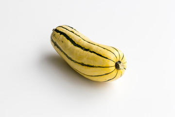 Fresh delicata squash centered and isolated on a white background.