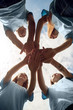 © Viktoriia - Volunteering. Young people volunteers outdoors standing hands together close-up bottom view smiling excited