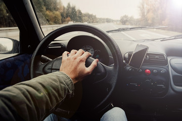 Wall Mural - Driving a car in the fall on a sunny day.  hand driver Business trip 