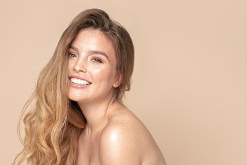 natural woman with toothy smile and freckles.