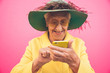 © oneinchpunch - Funny grandmother portraits. Senior old woman, interacting with a smartphone. Concept about seniority