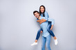 Profile photo of funny guy and lady holding piggyback playing leisure game rejoicing wear casual jeans clothes isolated grey color background