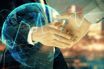 Double exposure of financial chart and world map on cityscape background with two businessmen handshake. Concept of international investment