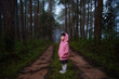 © Asada - Portrait of little kid girl wearing coat jacket standing in the forest at the morning time during rainy season.