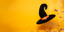Black Witch Hat, Dry Autumn Leaves On Blank Orange Background, Space For Text.