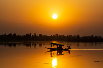 Sunset view over traditional boat or shikara - a type of wooden boat. Shikara are of varied sizes and are used for multiple purposes, including transportation of people.