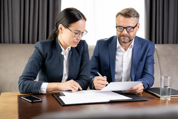 Wall Mural - Confident businessman showing his business partner where to sign contract