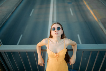 Wall Mural - A woman stands on the bridge above the road.