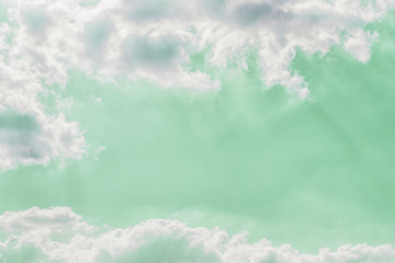 Wall Mural - Delicate light rays through clouds on a pastel green color sky background