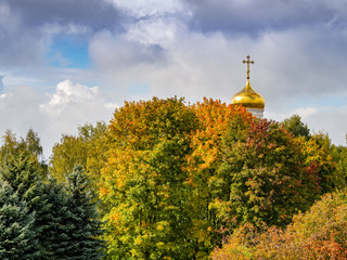 The golden dome of the Orthodox Church and the golden autumn foliage.