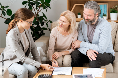 Fotografía Mature blonde woman listening to real estate agent while going to sign contract