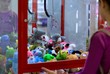 © Татьяна - Caucasian girl playing toy crane vending machine, Claw Game or Cabinet to Catch the Toys. Shopping, holiday activity, game of chance, vacation concept. Selective focus on crane.