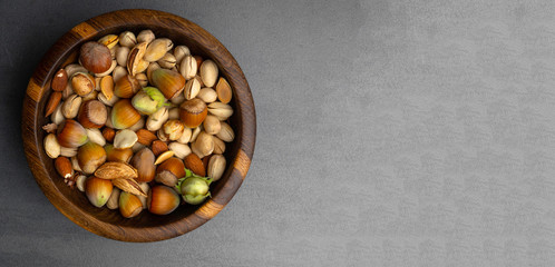 Wall Mural - banner of nuts mix in a wooden bowl, snack rich with vitamin E