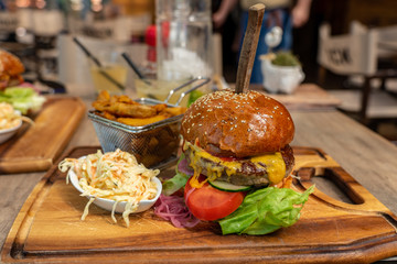 Eating burger together in a restautant with coleslaw and steak potato on a board