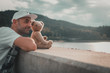 Mann mit Teddybär blickt über die Mauer auf den See