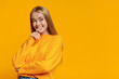 © Prostock-studio - Pensive teen girl looking upwards on orange studio background