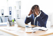 © Prostock-studio - Stressed african businessman sitting in office with hand on forehead