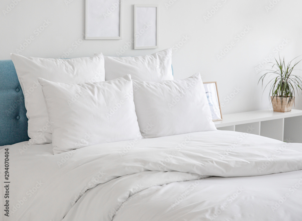 White pillows and duvet on the blue bed. White pillows, duvet and duvet case on a blue bed. White bed linen on a blue sofa. Bedroom with bed and bedding and poster frame mock up on the wall.Front view - obrazy, fototapety, plakaty 