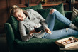 Christmas, cold autumn or winter day. Warming mood. Cheerful woman enjoy stayng at home drinking warm cocoa with marshmallows. Lazy weekend in knitted sweater on the couch. Cozy scene, hygge concept