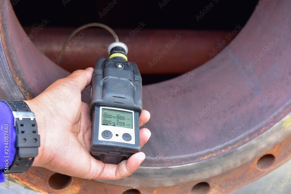 Human using the gas detector for detect combustible gas , flammable gas , toxic gas and oxygen depletion in a confined spaces before starting work. - obrazy, fototapety, plakaty 