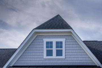 Wall Mural - Gable with horizontal vinyl lap siding, double hung window with white frame on a pitched roof at an American luxury single family home neighborhood in the USA, shingle facade