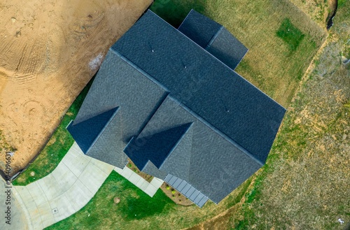 Aerial top down view of a hip and valley pitched roof on a new construction American luxury single family house real estate