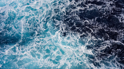 Texture of marine splashes. crashing ocean wave foam structure. Dark blue clear water. Ocean depth.