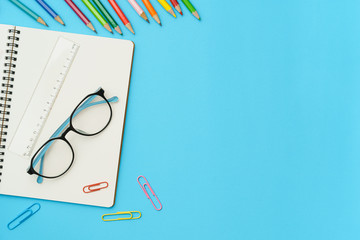 Wall Mural - flat lay photo of office desk with colorful pencil, paper clip, ruler, note book, glasses, top view 