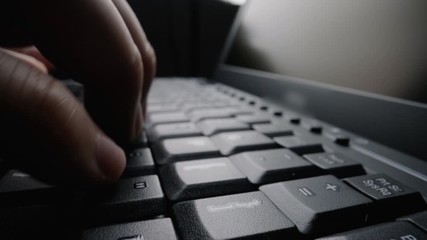 Wall Mural - close-up man typing on computer keyboard with hands and fingers. macro soft focus dolly shot. comput