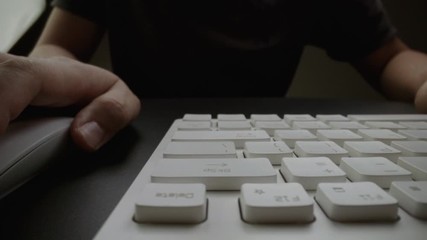 Wall Mural - close-up man typing on computer keyboard with hands and fingers. macro soft focus dolly shot. comput
