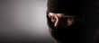 angry man in a balaclava on a dark background.