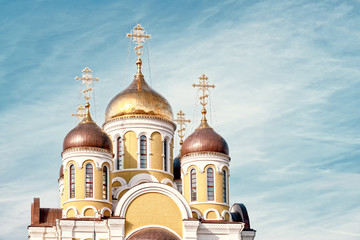 Wall Mural - orthodox golden church dome with gold cross against clouds blue sky closeup view of russian religion architecture cathedral building retro vintage stylized photo