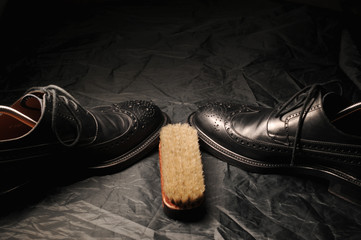 Leather black oxfords and brush. Studio photography