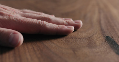 Wall Mural - closeup man hand check oiled black walnut surface