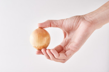 Woman hand hold full onion head on a white background