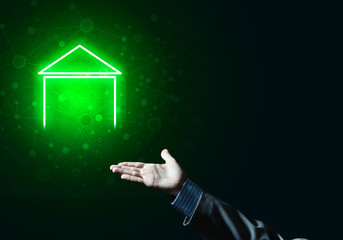 Conceptual image with hand pointing at house or main page icon on dark background