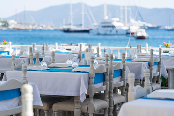 Wall Mural - Elegant table setting with fork, knife, wine glass, white plate and blue napkin in restaurant . Nice dining table set with arranged silverware and napkins for dinner