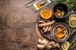 Turmeric ginger tea preparation with healthy ingredients on rustic wooden background, top view