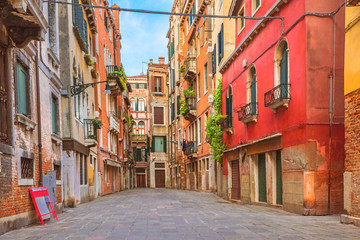 colorful houses in the old medieval street in venice, italy